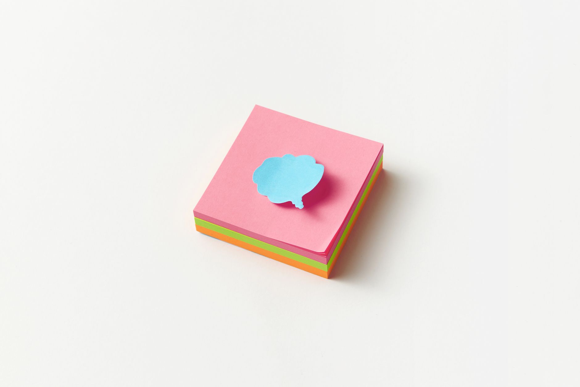 A stack of colorful sticky notes with a blue cloud-shaped note on top, perfect for creative office concepts.