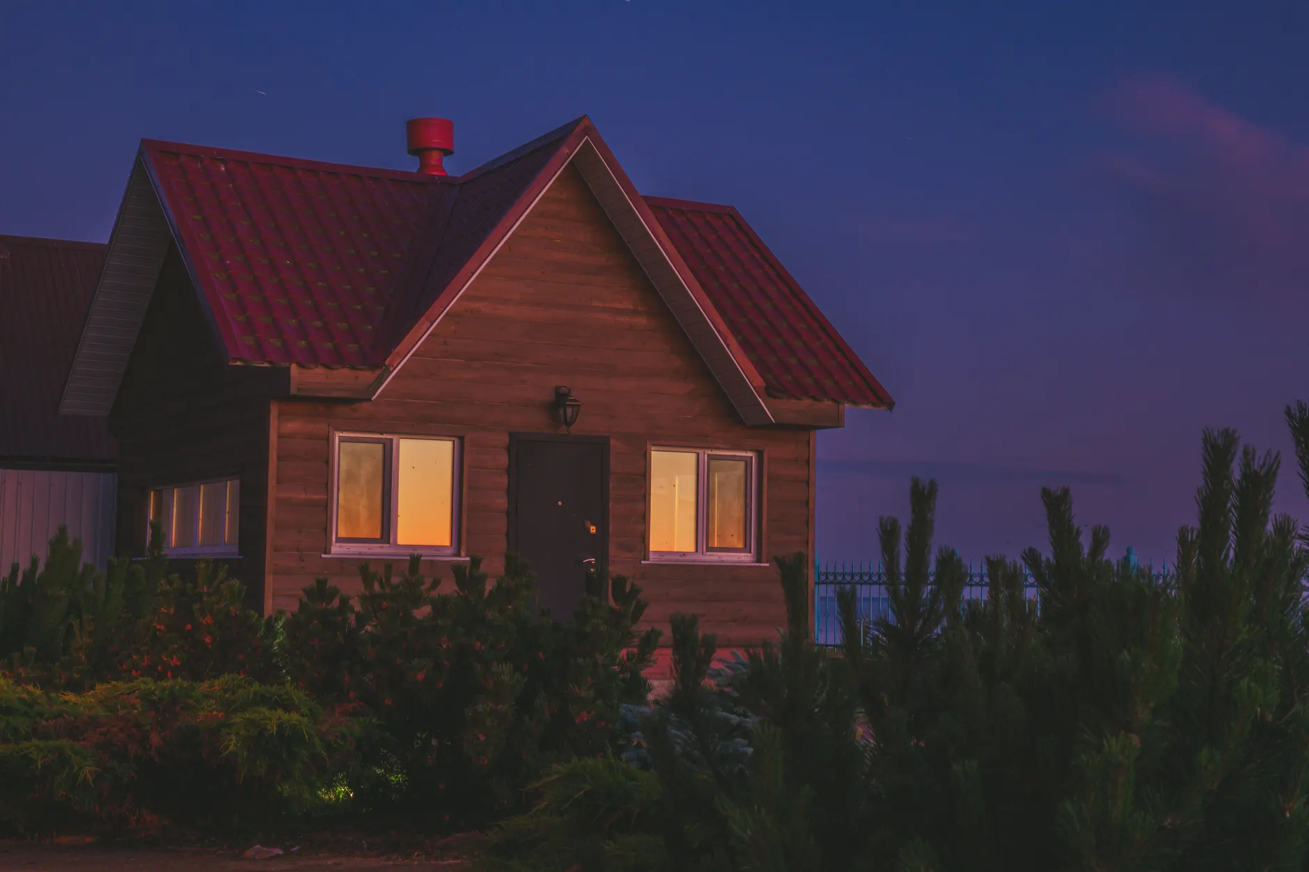 Twilight view of a cozy wooden cabin surrounded by nature in Vetvenik, Russia.